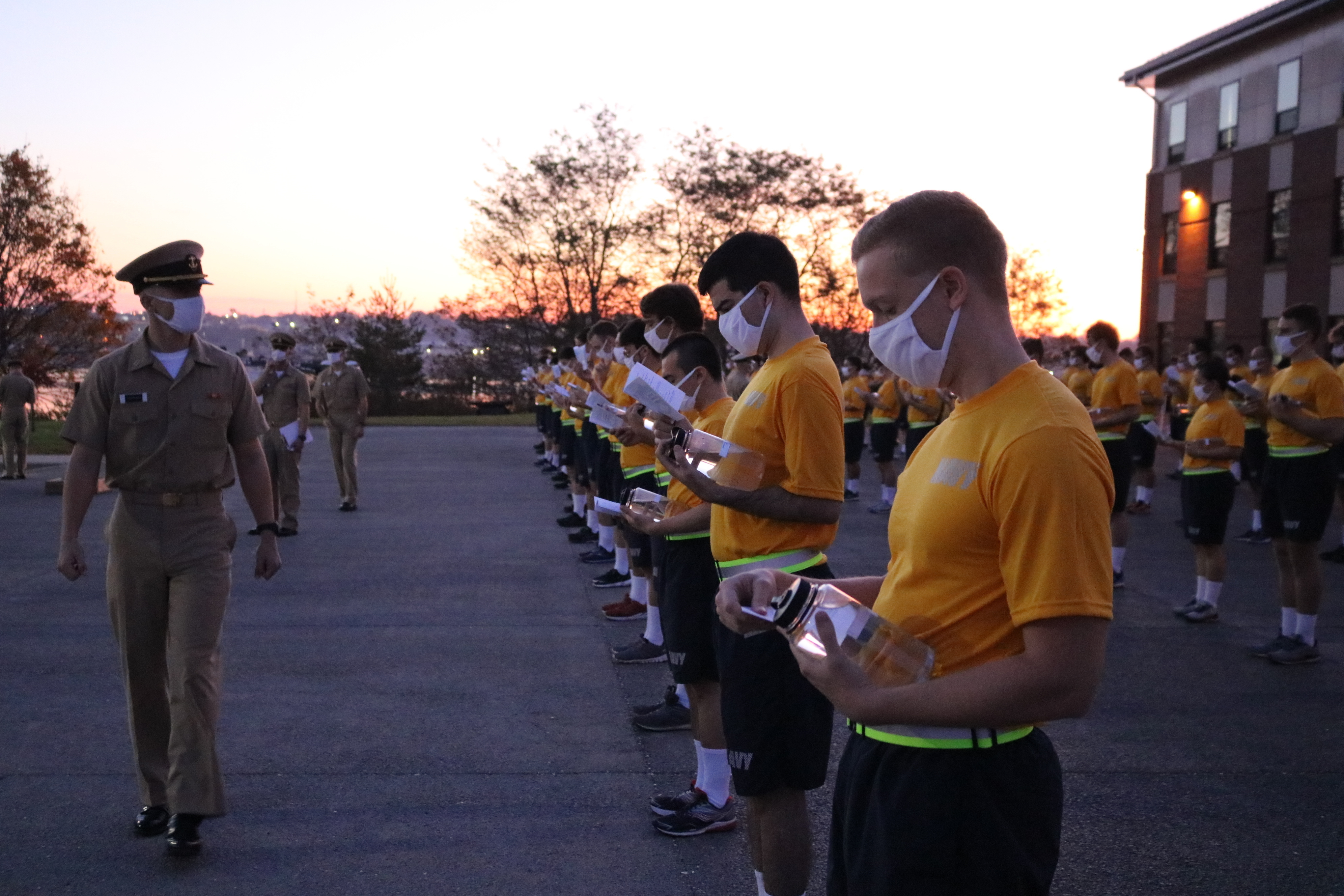 Newly arrived Navy OCS students reviewing gouge books in formation during check-in at Newport
