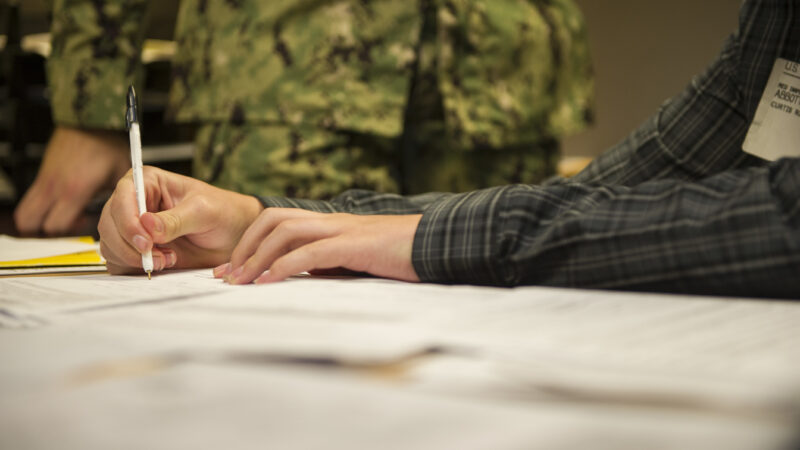 Curtis Abbott signs his Navy enlistment contract at the Kansas City, Mo., Military Entrance Processing Station (MEPS). He and his mother