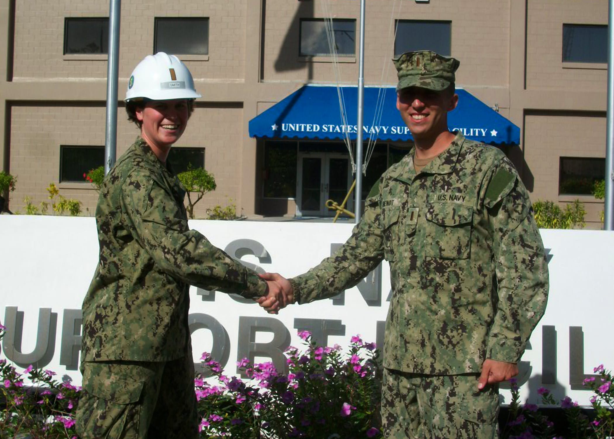 Navy officer discussing job opportunities with a civilian contractor at a career fair