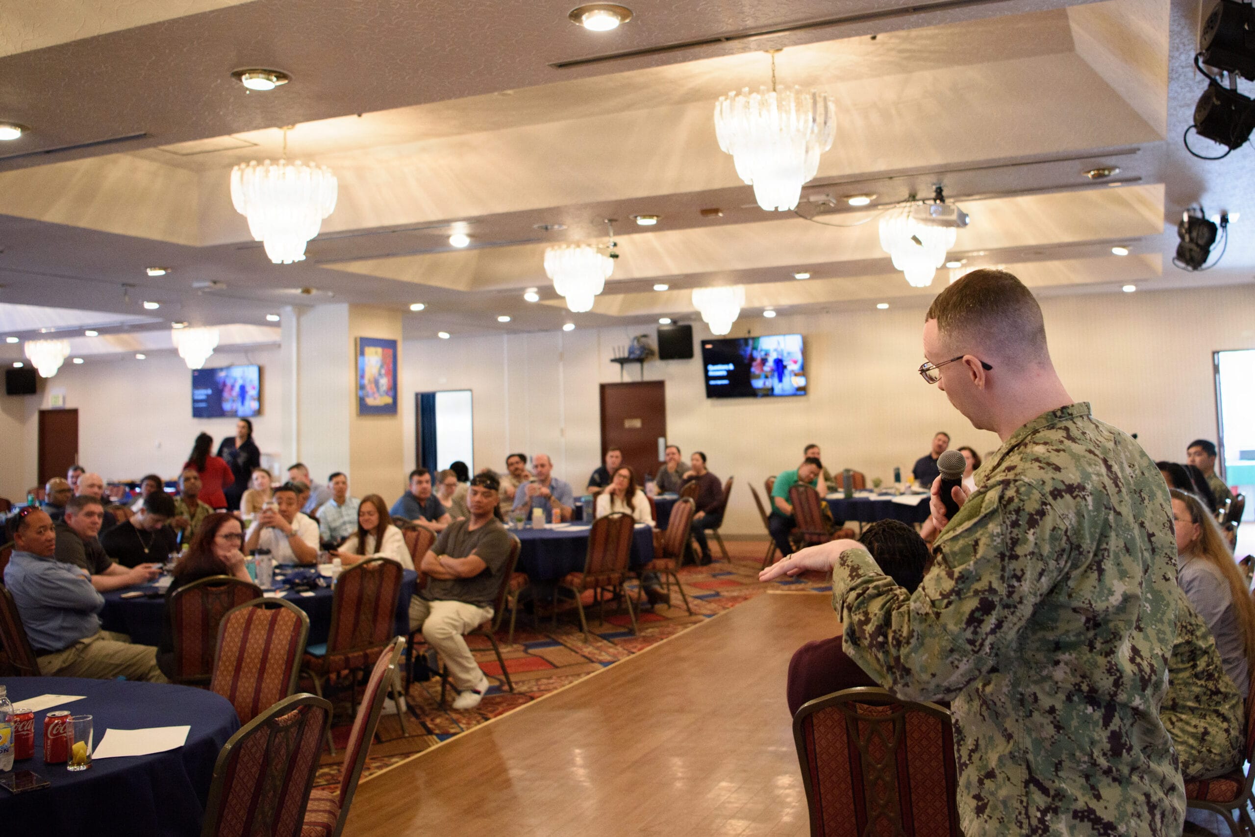 A Navy officer reviewing financial documents on a laptop