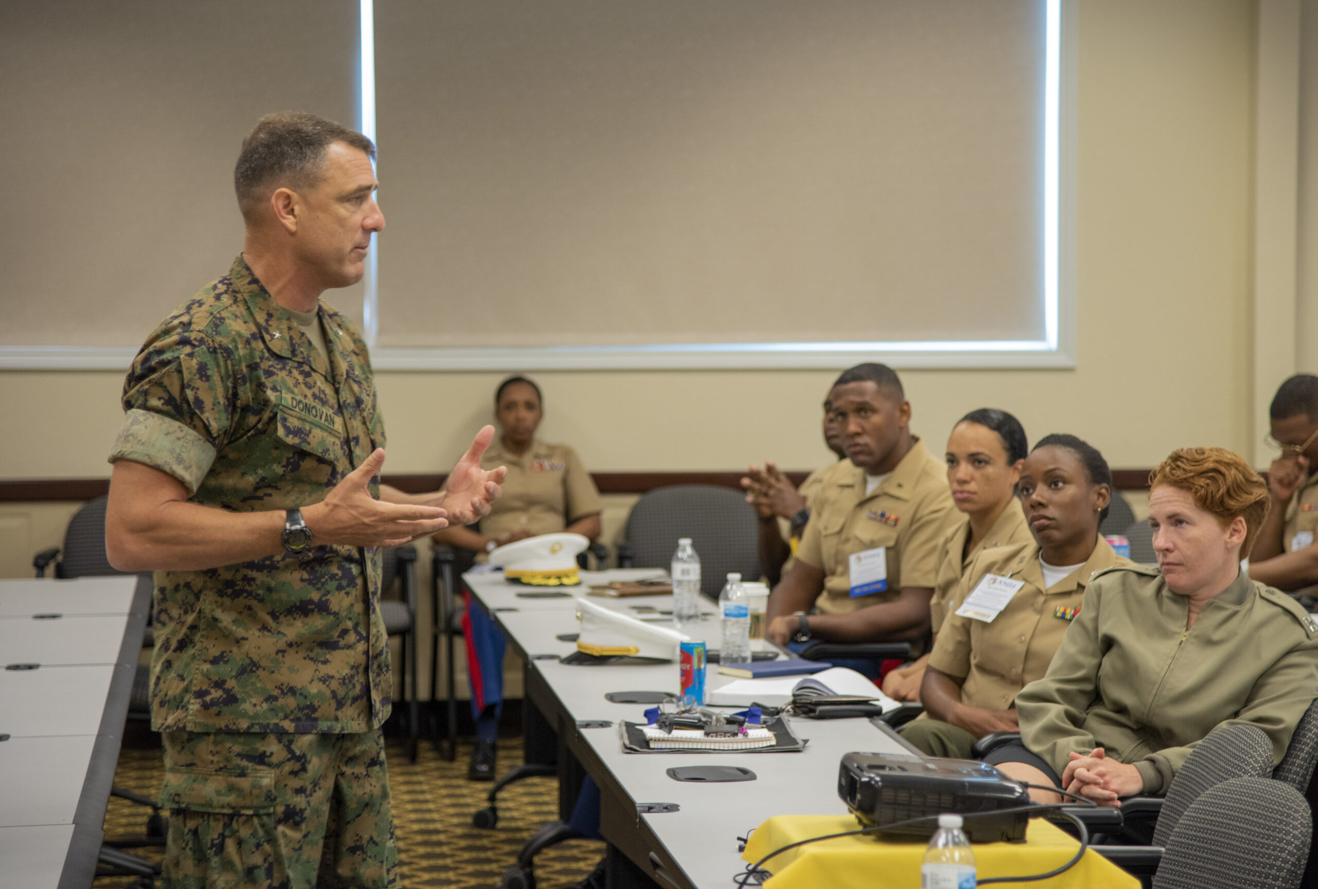 An intelligence officer delivering a briefing to senior officers