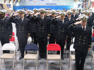 Navy officer candidates salute during their Officer Candidate School graduation at OTC Newport