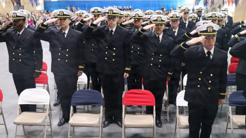 Navy officer candidates salute during their Officer Candidate School graduation at OTC Newport