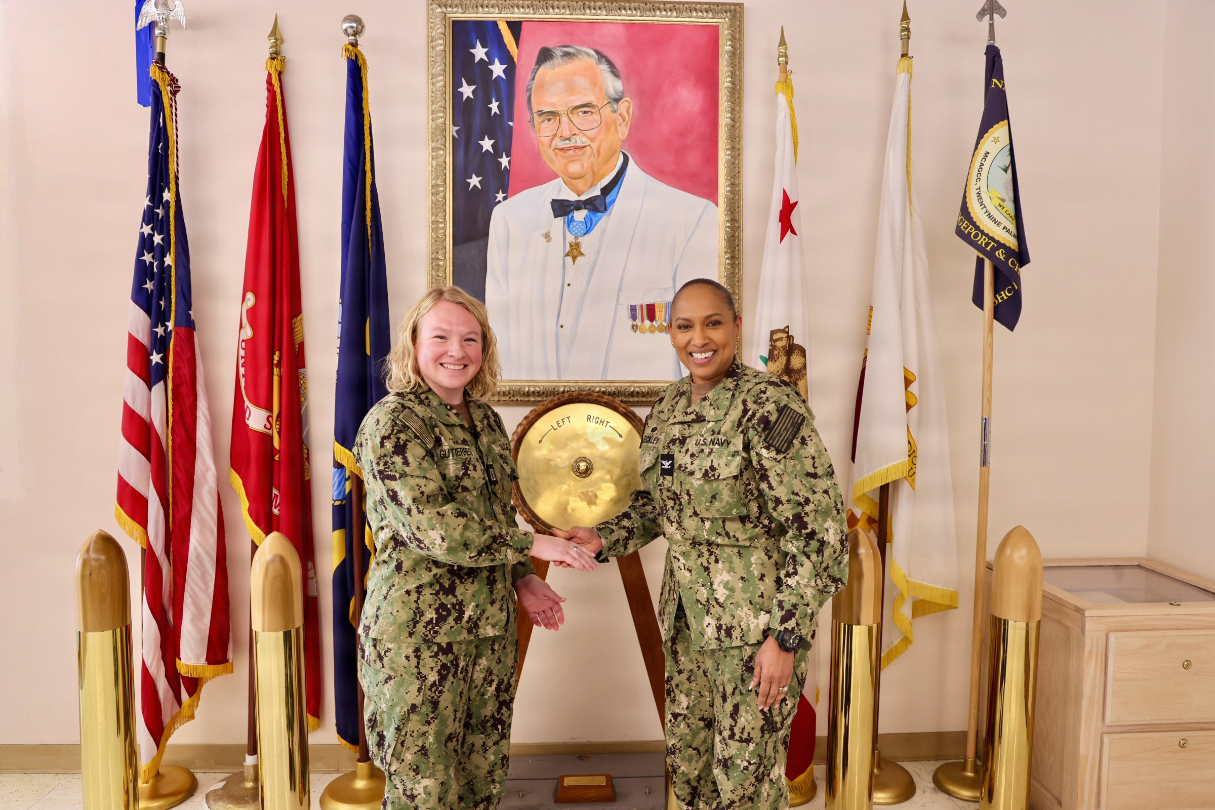 A Navy officer in dress uniform, representing the O-4 couple