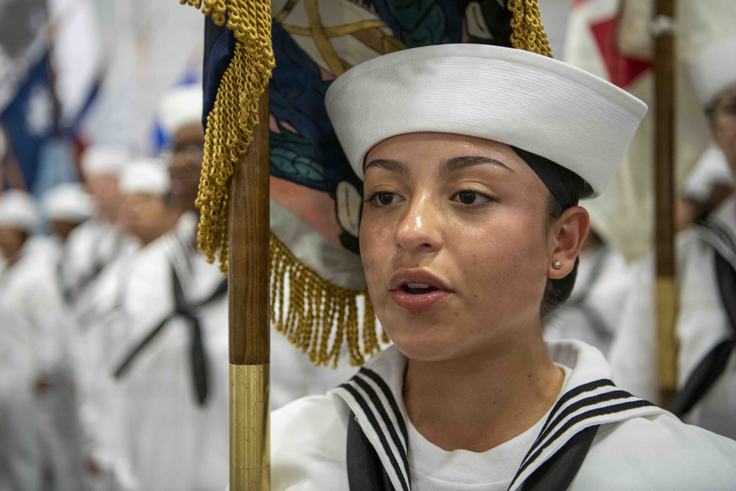 Navy boot camp graduates throwing caps in the air
