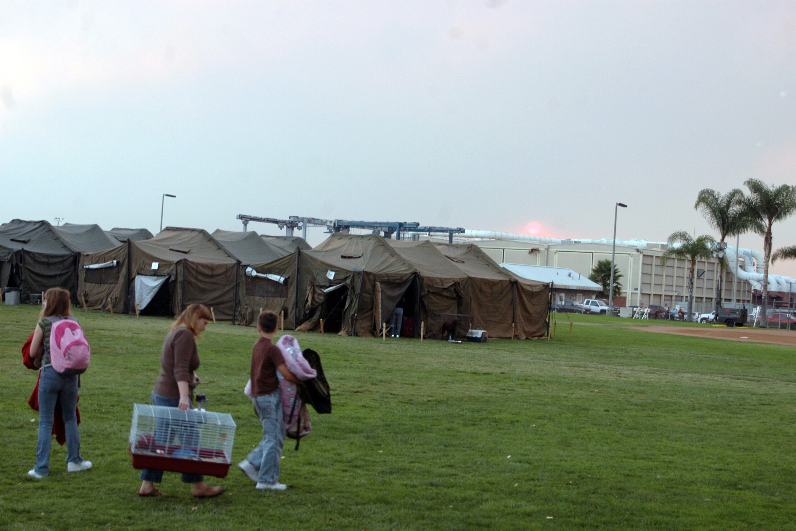 A military family carrying boxes into a new home